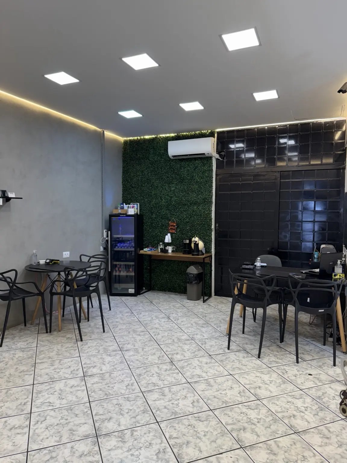 Espaço de atendimento Direct Repair com mesas, cadeiras e frigobar