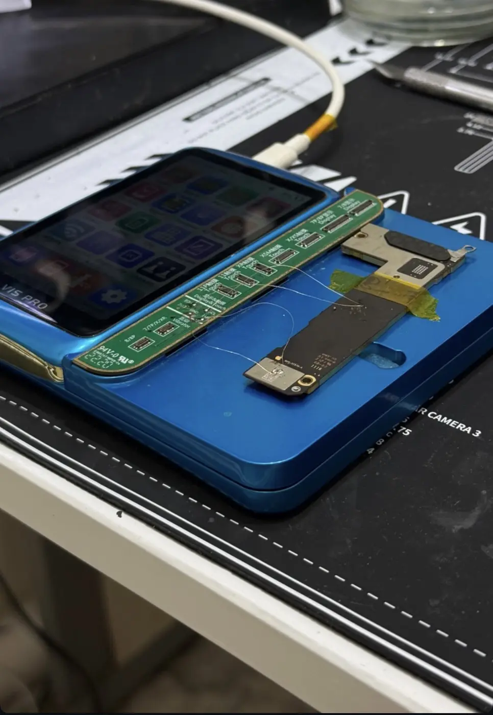 Placa lógica de smartphone em equipamento de reparo com jumpers